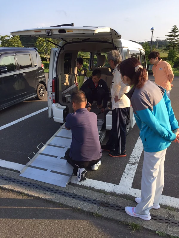 車いすをスロープから車内へ乗せる実演