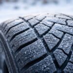 雪がうっすら積もった冬タイヤの溝のアップ