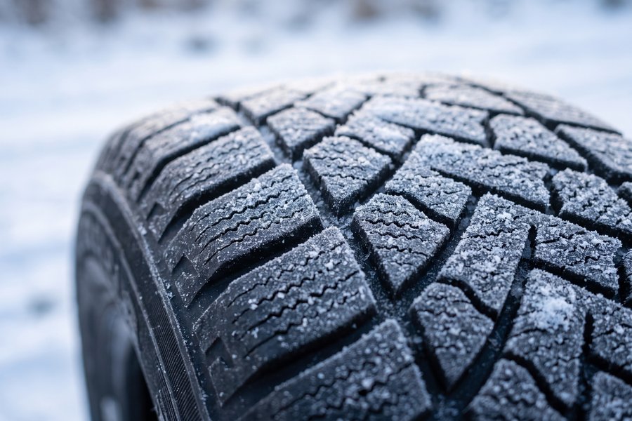 雪がうっすら積もった冬タイヤの溝のアップ